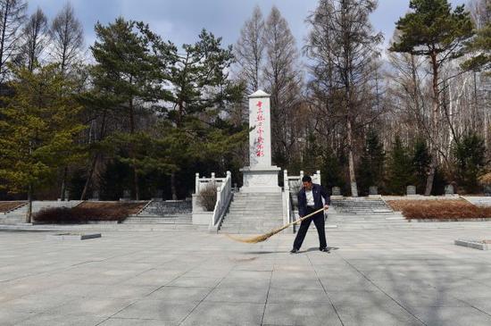 刘国信在打扫烈士陵园。