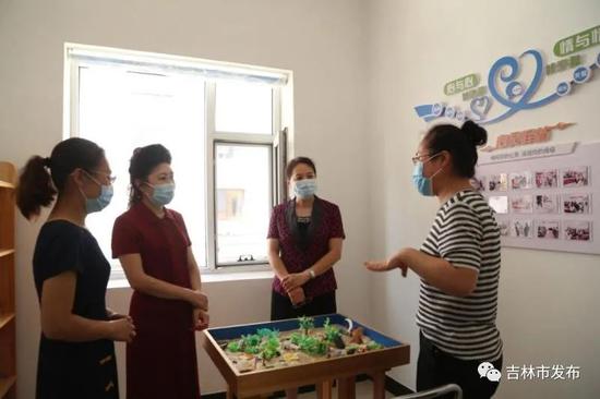 吉林市妇联负责人(左二)在听社区工作人员讲述工作情况