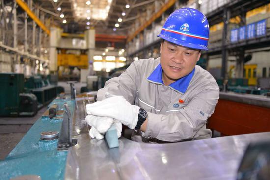 冯斌正在车间研磨模具。陈 亮摄