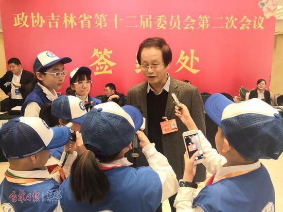 省政协委员完成报到程序后，接受新华小记者的采访。