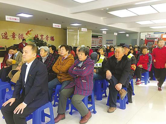 长山花园社区居民党员在看全国两会报道。