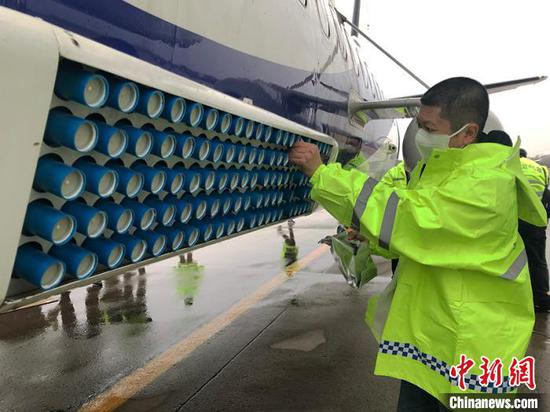 气象工作人员在人工增雨飞机新舟60上安装焰弹。 （资料图）　郭佳摄