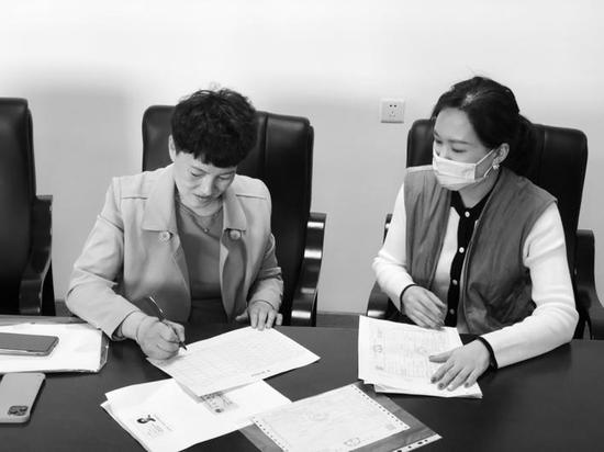 白城市民张女士(左)办理兑奖手续。
