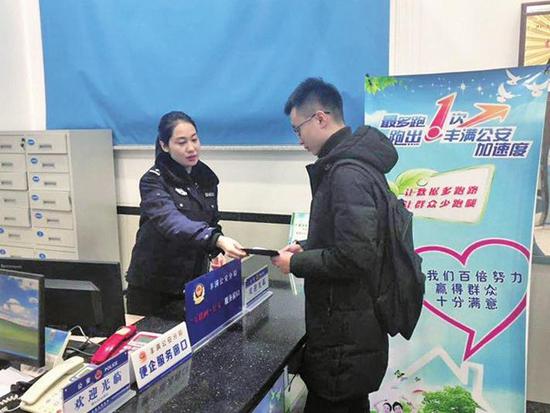 派出所民警向群众介绍互联网+公安户籍服务措施