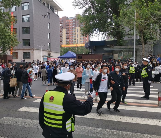 学生走出考场,警察维护秩序。 于悦 摄