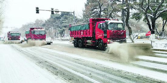 清雪车在清理路面积雪。李成伟 摄