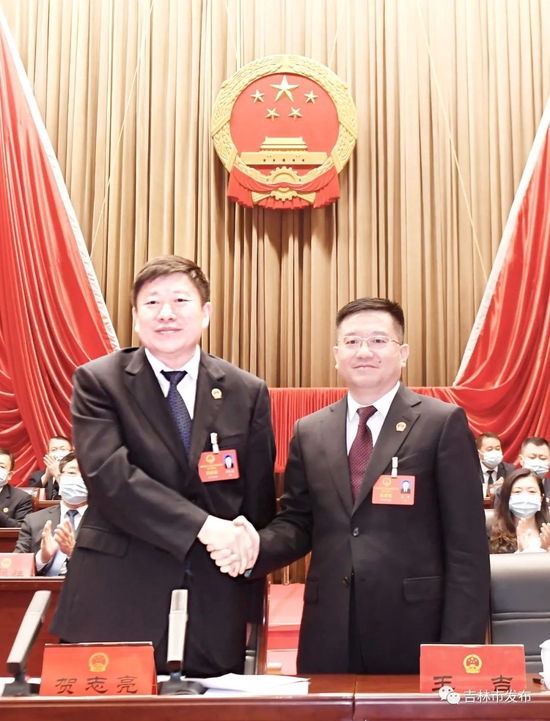 吉林市委书记贺志亮（左）和新当选的吉林市市长王吉握手。