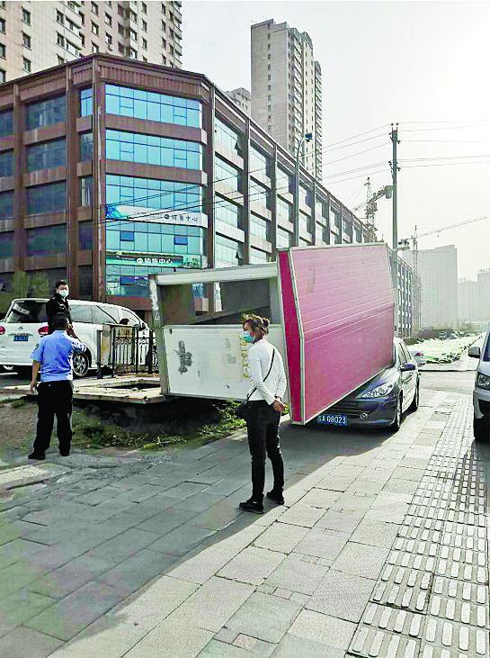  吉林大路吉林街附近，一废旧彩钢房被风刮倒砸中一辆车