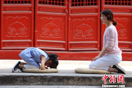5月13日“大哉儒道 行孝承义”母亲节活动在孔子故里曲阜举行。图为,参与活动的家庭现场体验向母亲行古礼。 刘鸿儒 摄