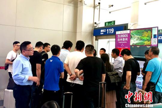 图为大批乘客向成都双流机场工作人员了解延误原因。 黄心玥 摄