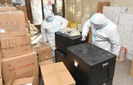 在吉林省通化市东昌区老站街道办事处，工作人员在搬运盒饭（2月2日摄）。