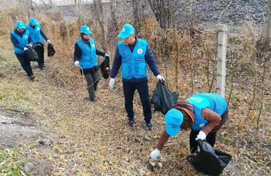 ▲ 延吉市政府办工作人员在创城工作中开展创城志愿服务活动，清理路旁白色垃圾。