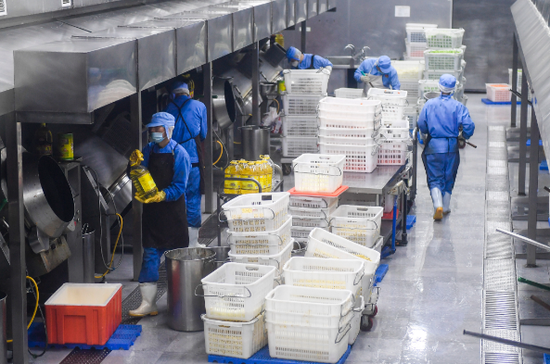工作人员在车间内炒制菜品（1月21日摄）。