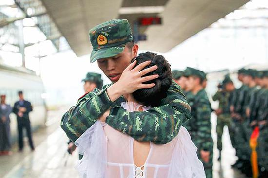别离一年多后,刘巧玉和妻子在站台相拥。