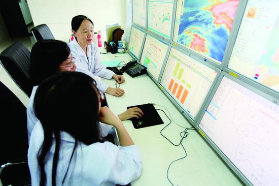 在吉林省人工影响天气办公室地面指挥中心,工作人员对飞行条件及天气情况进行实时跟踪。