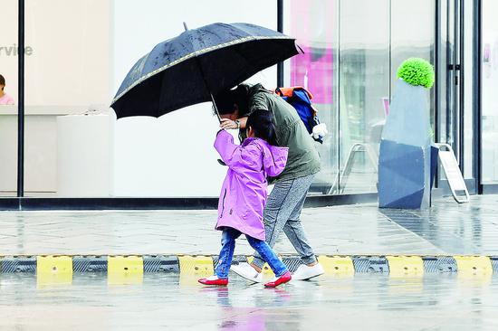 降雨、降温让市民重新穿上厚外套。 张扬 摄