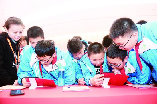 4月12日,小学生在第五届中国数字阅读大会主题展区体验数字阅读。 (新华社发)