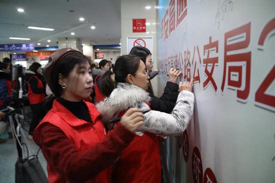 共青团吉林省委志愿者在背景墙上签名