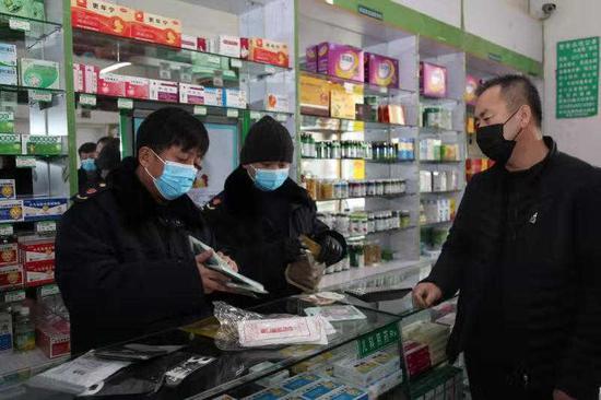 池弘国（左一）对药店销售口罩是否哄抬价格进行检查