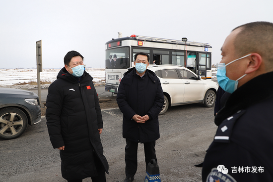 吉林市委书记贺志亮(左)在舒兰平安镇新发高速疫情防控执勤点了解疫情防控措施落实情况,并对工作人员致以节日问候。