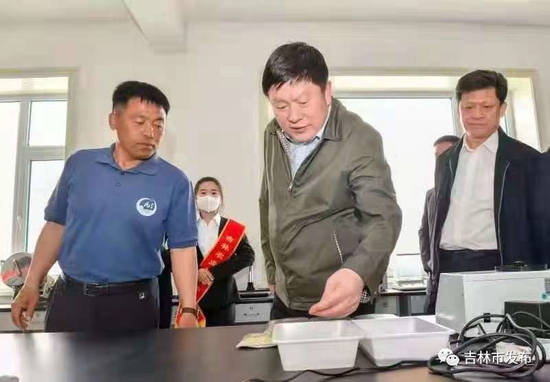 吉林市委书记贺志亮(中)在永吉县一拉溪镇九月丰家庭农场,调研家庭农场高质量发展情况。