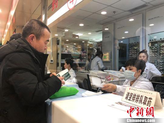 一位老者在吉林大学中日联谊医院药房前取药。 郭佳 摄
