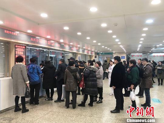 在吉林大学中日联谊医院药房前,人们在排队取药。 郭佳 摄