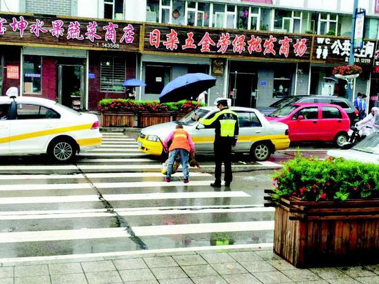 近日,在通化辉南县发生了这样温暖的一幕,一位环卫工人在雨中打扫街道,一名交通警察冒雨走到车流中悄悄为环卫工人撑起雨伞。阵阵秋雨给城市带来了一丝凉意,一个细微的举动为人们送去了温暖。 宋佳明摄