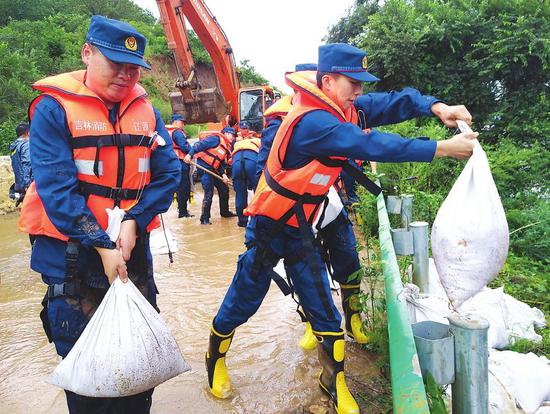 消防救援人员与当地干部群众抓紧抢护路基，确保安全通行。本报记者 隋二龙 摄