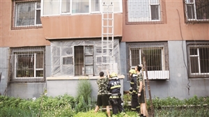 消防官兵架梯开门。 李成伟 摄