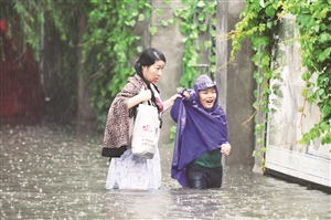 市民在雨中趟水前行。张扬 摄