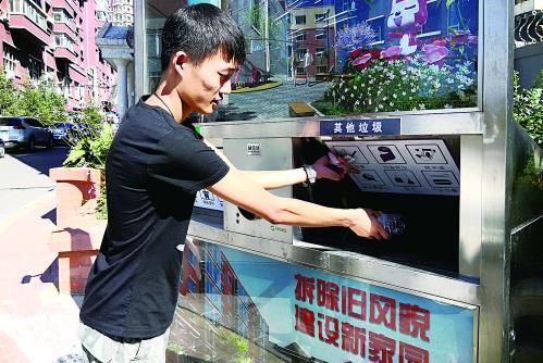 小区居民将垃圾分类后投放到智能垃圾箱里。 孙建一 摄