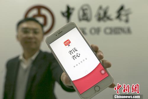 资料图:银行工作人员展示“云闪付”APP。中新社记者 张云 摄