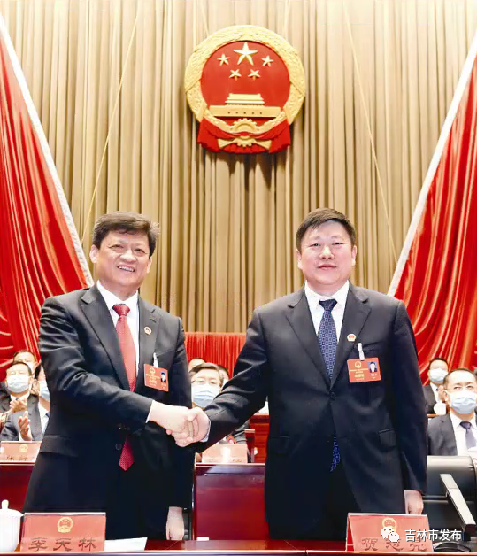 吉林市委书记贺志亮(右)与新当选的吉林市人大常委会主任李天林握手表示祝贺。