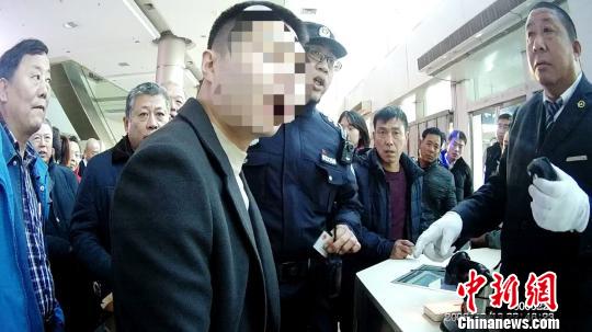该男子借着酒劲霸住旅客进站口致30多名旅客无法乘车 大连铁警供图 摄