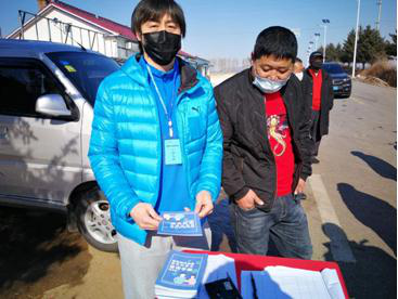 长春市委党校张映辉（左一）在四家乡卡点向群众发放防疫宣传手册