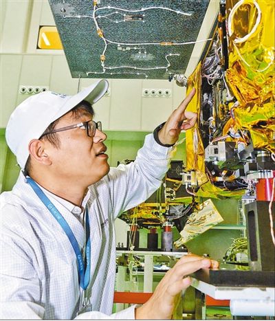 “吉林一号”高分03卫星系列总师陈茂胜在长光卫星总装测试大厅检测卫星。人民网记者 李洋摄