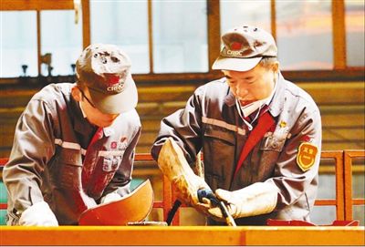 中车长客高级技师李万君(右)和徒弟王善更在焊接轨道客车转向架。人民日报记者 赵树宴摄