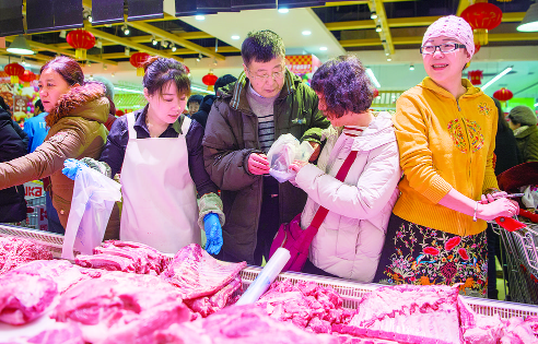 春节期间，市民在市场选购肉品，丰富节日餐桌。 张扬 摄