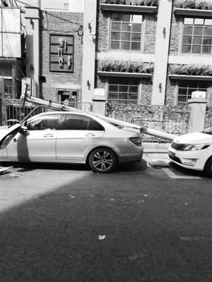 路灯杆被大风刮倒砸在车上。市民供图