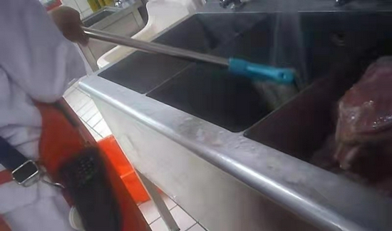 6月22日，一名员工在洗肉池里冲洗拖把。新京报调查暗访组