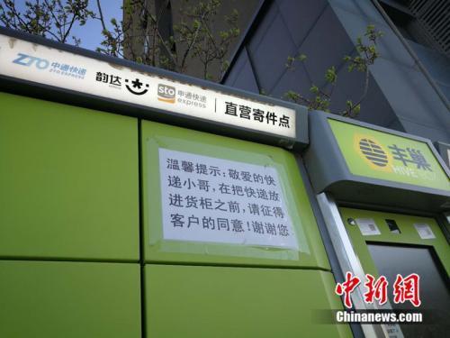 资料图:北京市某小区外的快递柜上张贴提示,提醒快递员放进货柜前首先征得收件人同意。中新网 邱宇 摄