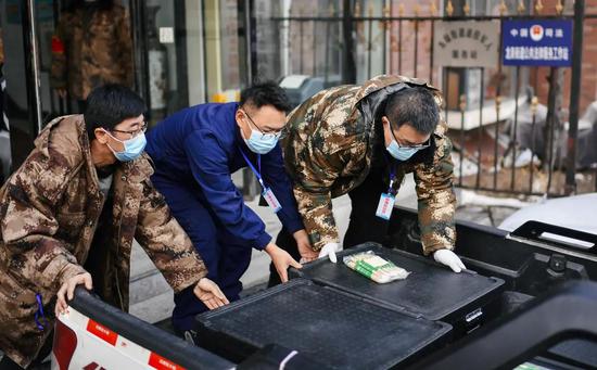 在吉林省通化市东昌区龙泉街道办事处，收到盒饭的街道工作人员将盒饭装车发往各社区卡点（1月23日摄）。