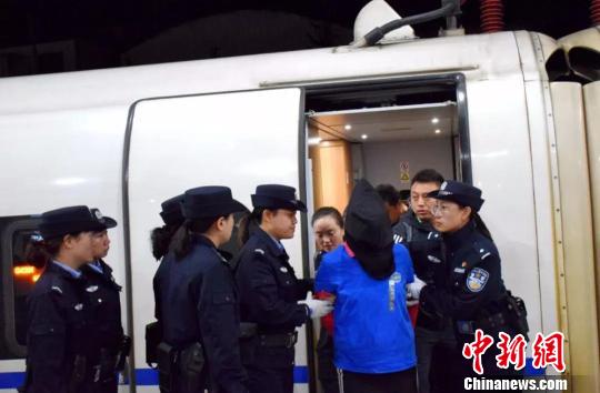 图为押解犯罪嫌疑人现场图。 钟欣 摄