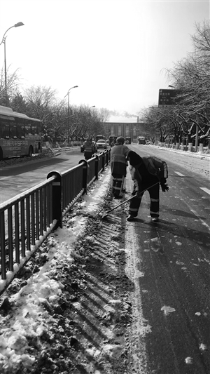环卫工人正在清理积雪。本组摄影 于慧