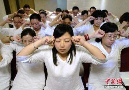 资料图:长沙首个睡眠班开课,学员们身穿白色睡衣做睡眠操。中新社发 杨华峰 摄