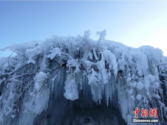 洞顶被大雪覆盖、长短不一的冰溜悬挂于洞中