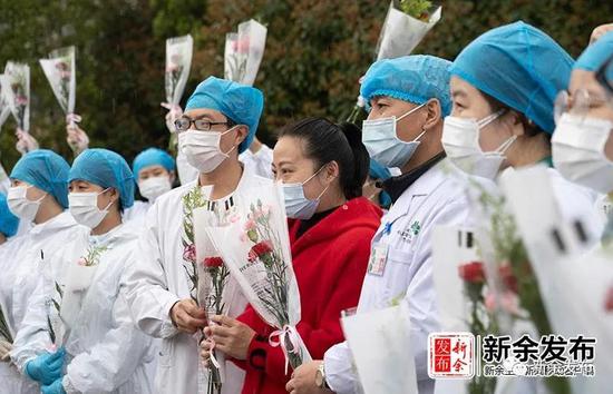 2020年3月9日,江西省新余市最后一名新冠肺炎确诊病例出院与医护人员留影。(新余日报记者 赵春亮摄)