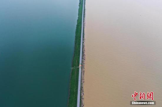 7月12日下午,航拍位于鄱阳湖东岸的江西鄱阳县珠湖联圩,一侧为清澈的鄱阳湖内湖珠湖,一侧为因暴雨变浑浊的鄱阳湖外湖,呈现一堤之隔泾渭分明的景观。(资料图) 刘占昆摄