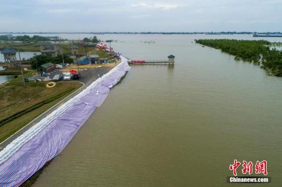 图为江西湖口县上万人紧急加筑万米堤坝抵抗洪魔。(资料图) 李学华摄